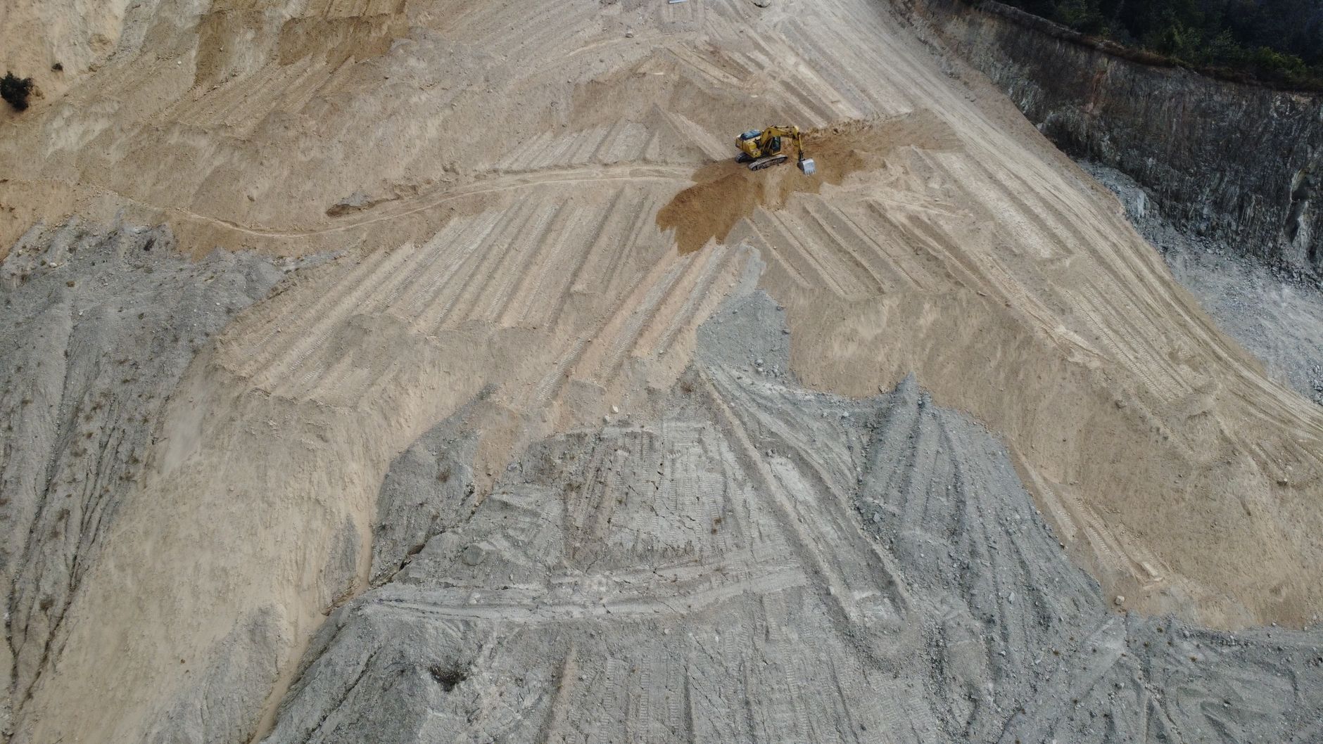 A large cut and fill operation with a machine working the face