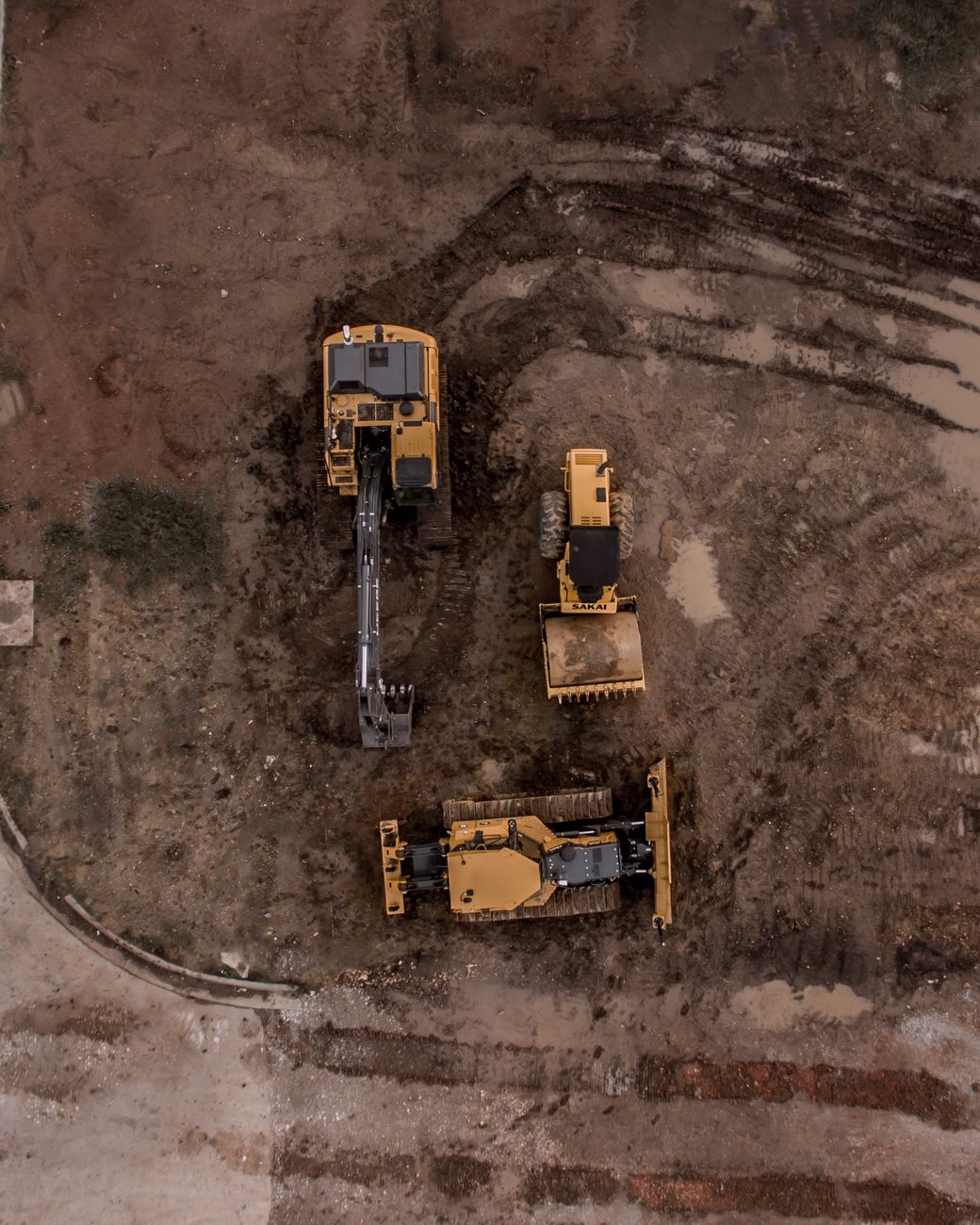 Two bulldozers working a large earth platform, seen from above