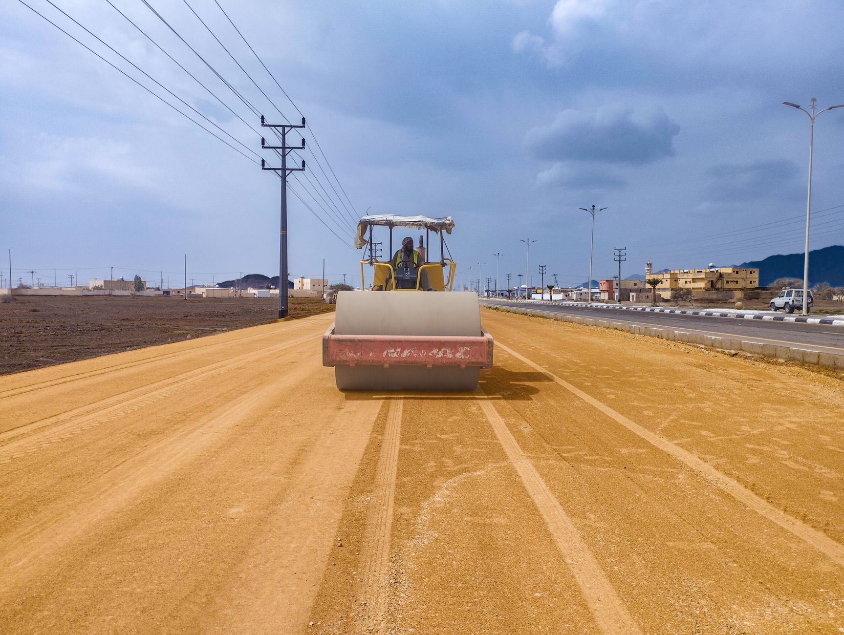 A roller compacting a metalled surface